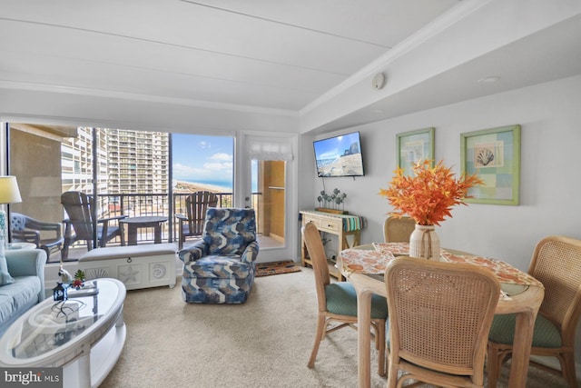 carpeted dining space with crown molding