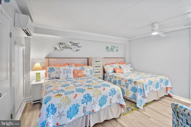 bedroom featuring a wall mounted air conditioner, wood-type flooring, ceiling fan, and ornamental molding