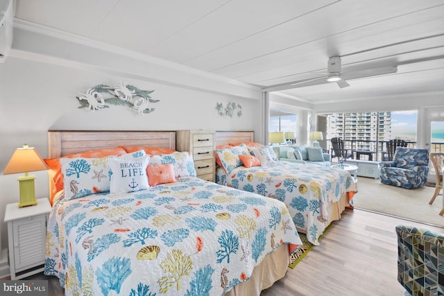 bedroom with multiple windows, ceiling fan, hardwood / wood-style floors, and ornamental molding