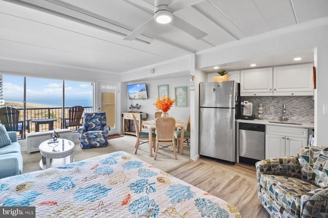 bedroom featuring access to exterior, ornamental molding, ceiling fan, sink, and stainless steel refrigerator