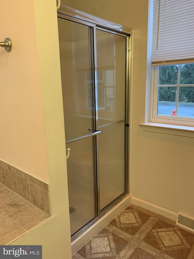 bathroom featuring a shower with shower door