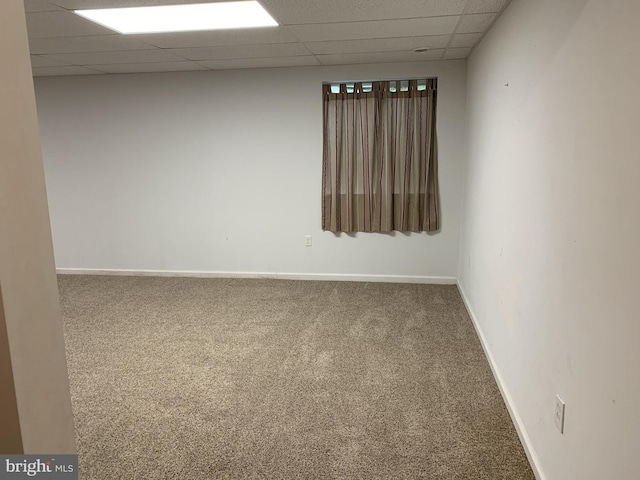 unfurnished room featuring carpet floors and a paneled ceiling