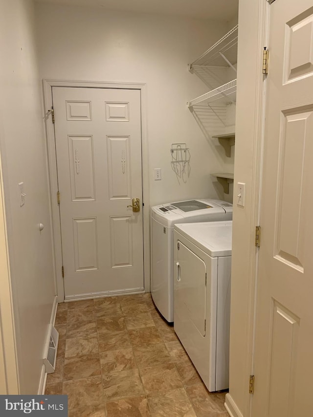 clothes washing area with washing machine and dryer