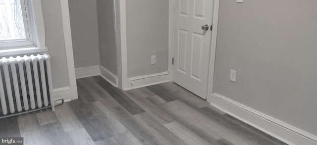 hallway with hardwood / wood-style flooring and radiator