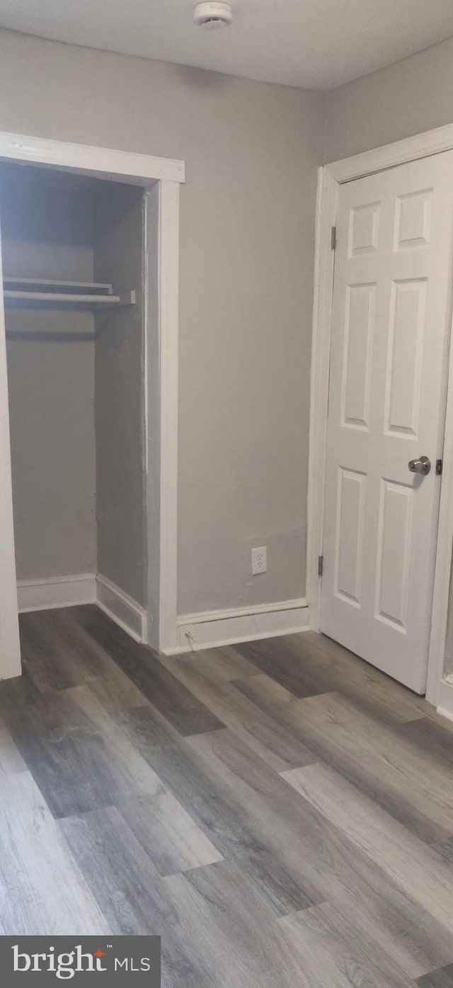 unfurnished bedroom with hardwood / wood-style floors and a closet