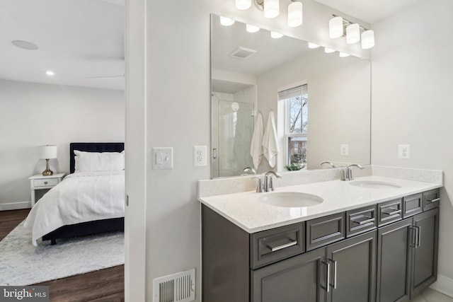 bathroom featuring a shower with door, vanity, and wood-type flooring