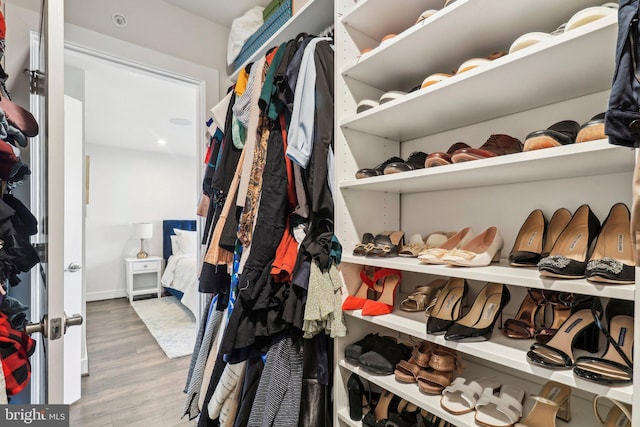 walk in closet with light hardwood / wood-style flooring