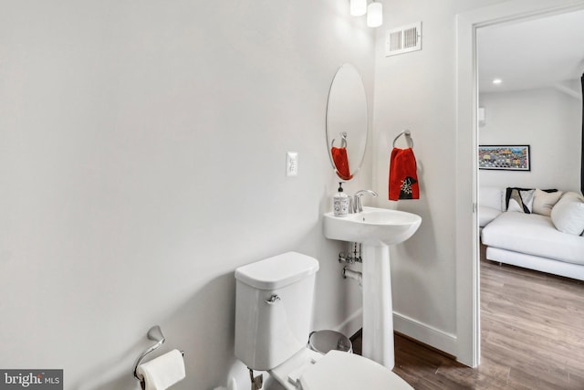 bathroom with toilet and wood-type flooring