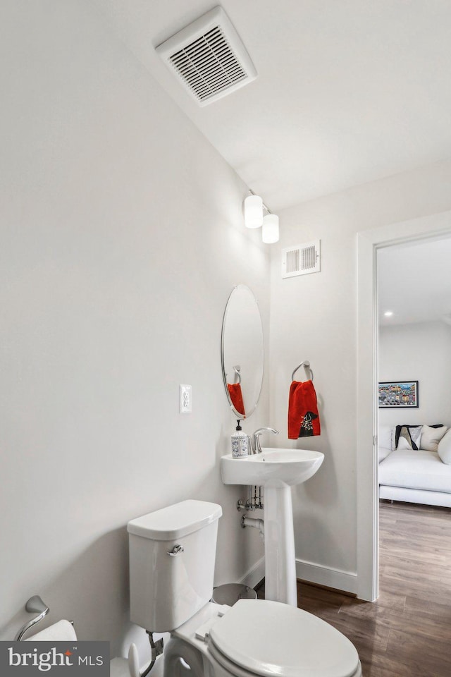 bathroom featuring hardwood / wood-style floors and toilet