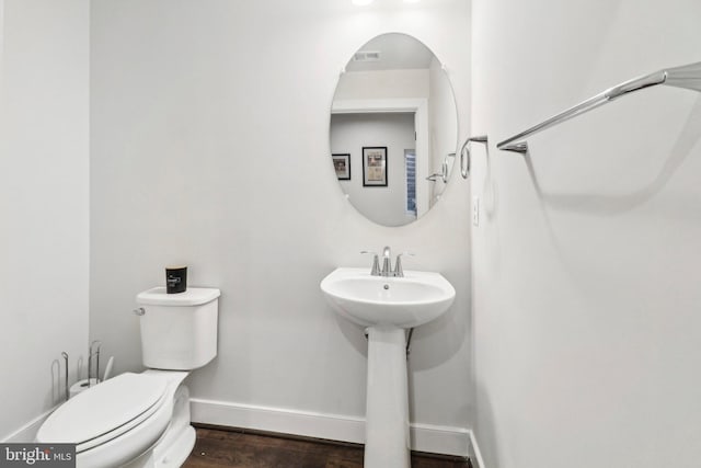 bathroom with wood-type flooring, toilet, and sink