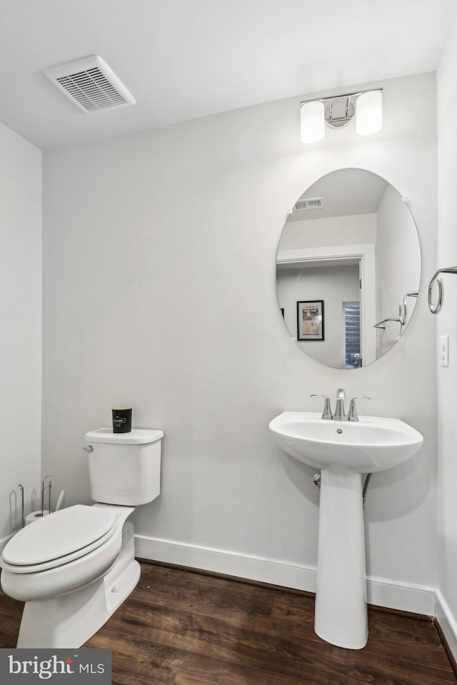 bathroom with toilet, wood-type flooring, and sink