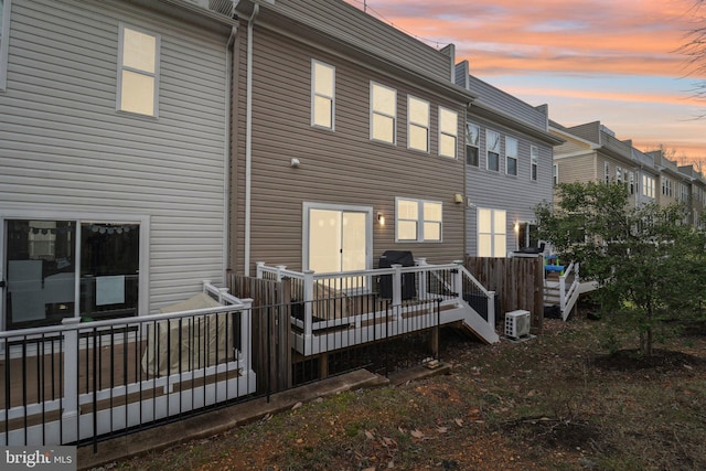 back house at dusk featuring a deck