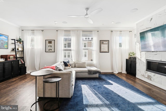 living room with ceiling fan, dark wood-type flooring, a healthy amount of sunlight, and ornamental molding