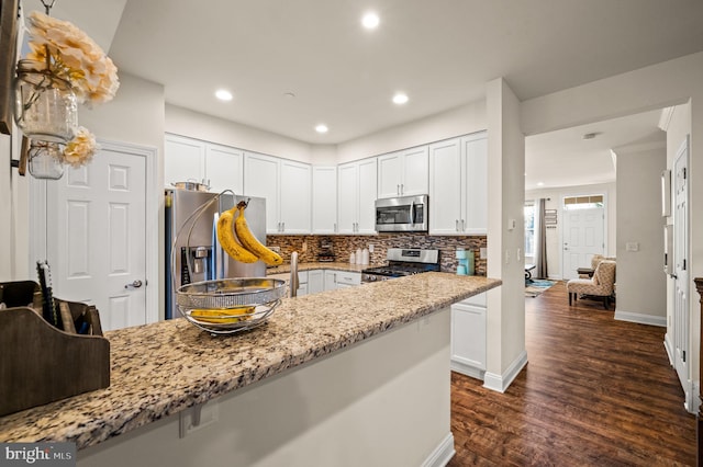 kitchen with white cabinets, dark hardwood / wood-style floors, and appliances with stainless steel finishes