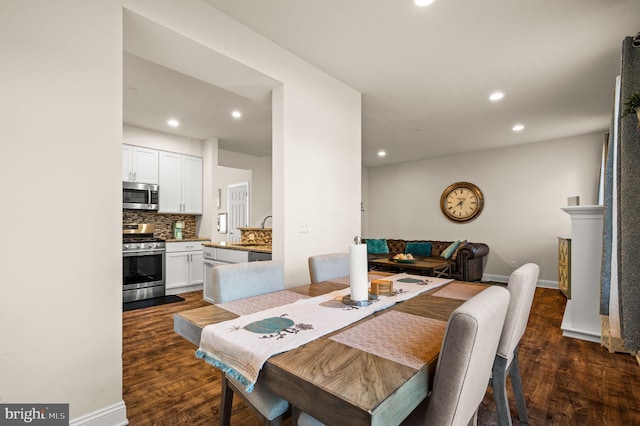 dining space featuring sink and dark wood-type flooring