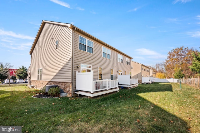 back of property with central air condition unit, a lawn, and a wooden deck