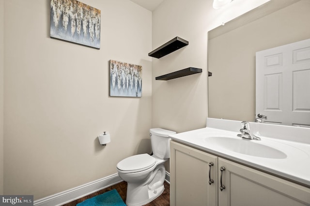 bathroom featuring vanity, wood-type flooring, and toilet