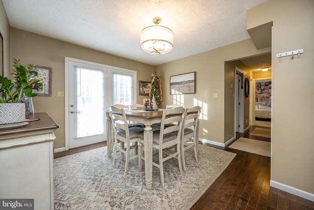 dining area with a textured ceiling and dark hardwood / wood-style floors