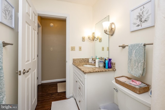 bathroom with vanity, toilet, and wood-type flooring