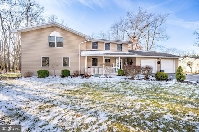 view of front property featuring a porch, a garage, and a lawn