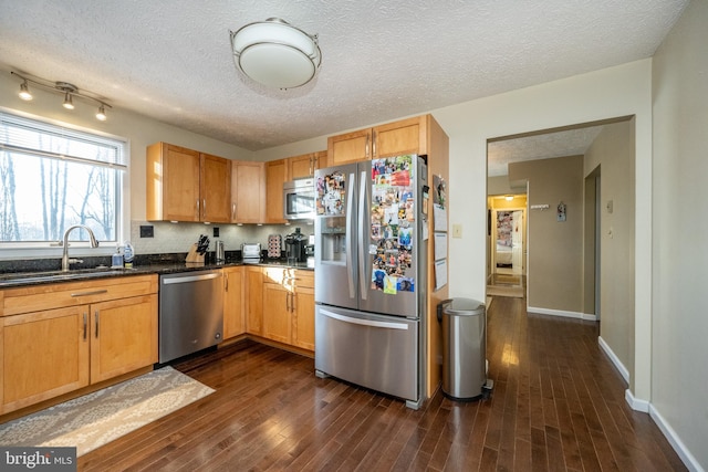 kitchen featuring dark hardwood / wood-style flooring, sink, stainless steel appliances, and a textured ceiling