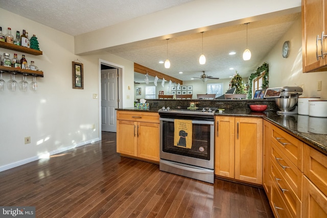 kitchen with dark hardwood / wood-style flooring, a textured ceiling, dark stone countertops, and stainless steel range oven