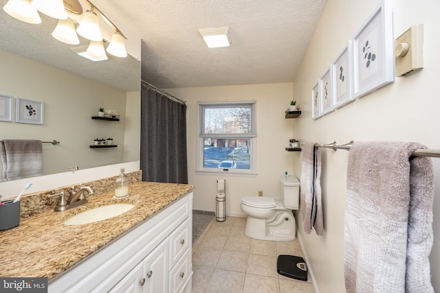 bathroom with tile patterned flooring, vanity, a textured ceiling, and toilet