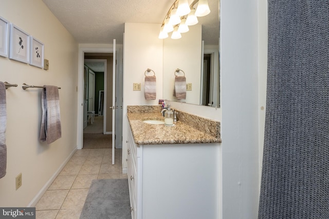 bathroom with vanity, a textured ceiling, and tile patterned floors