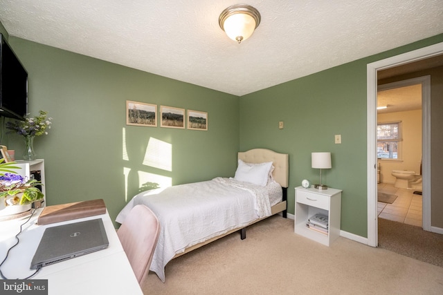 carpeted bedroom featuring a textured ceiling and connected bathroom