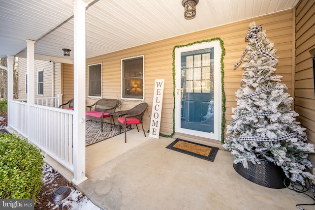 view of exterior entry featuring covered porch