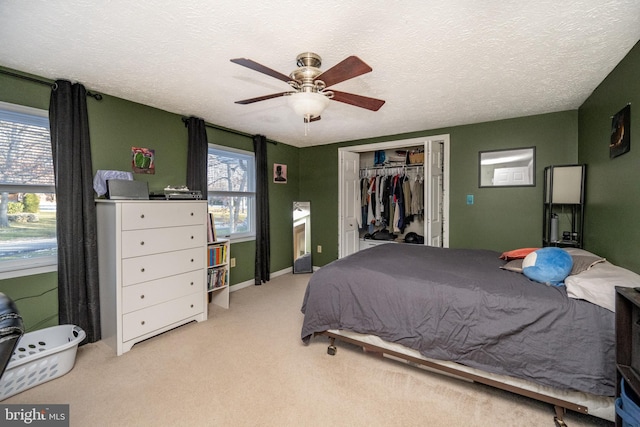 carpeted bedroom featuring a textured ceiling, a closet, and ceiling fan