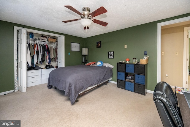 carpeted bedroom with a textured ceiling, a closet, and ceiling fan