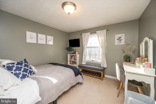 bedroom featuring light carpet and a textured ceiling