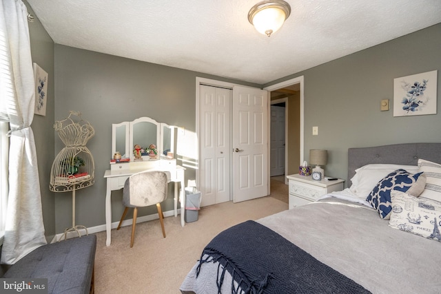 bedroom with light carpet, a textured ceiling, and a closet