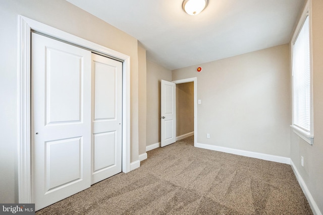 unfurnished bedroom featuring carpet flooring and a closet