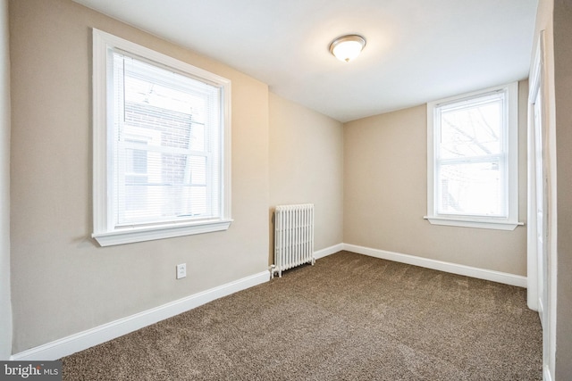 unfurnished room with carpet flooring and radiator heating unit