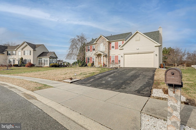 view of front of property with a garage and a front lawn