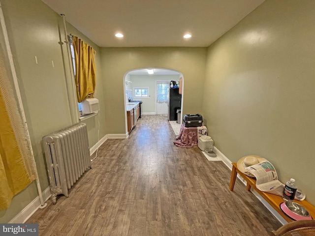 hallway featuring radiator heating unit and wood-type flooring