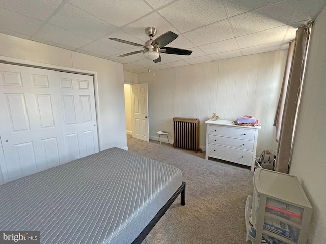 carpeted bedroom featuring a paneled ceiling, a closet, and ceiling fan