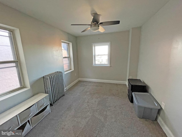 interior space featuring ceiling fan, light carpet, and radiator