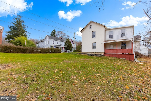 rear view of house with a porch and a yard