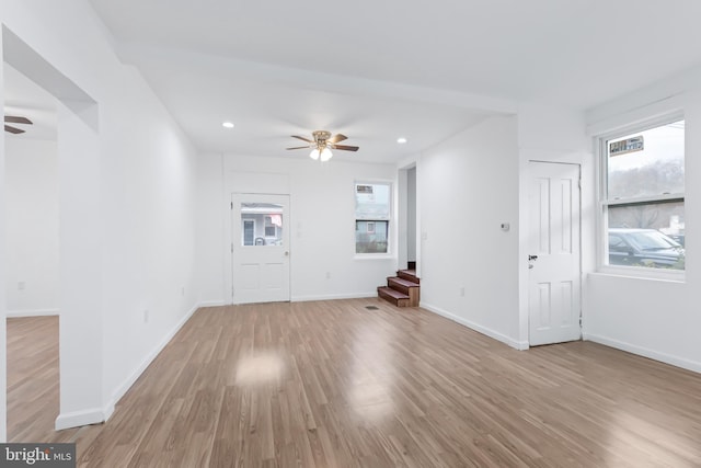 unfurnished living room with ceiling fan and light wood-type flooring