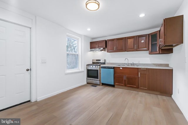 kitchen with appliances with stainless steel finishes, light hardwood / wood-style flooring, and sink