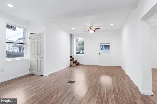 unfurnished living room featuring ceiling fan and light hardwood / wood-style flooring