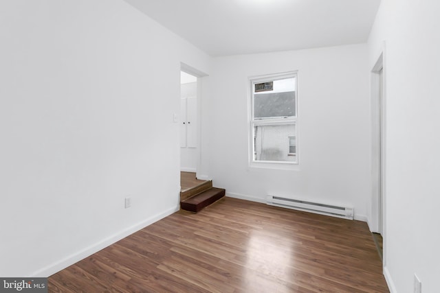 empty room featuring dark hardwood / wood-style floors and a baseboard radiator