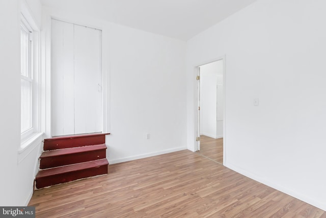 unfurnished bedroom featuring light wood-type flooring and a closet