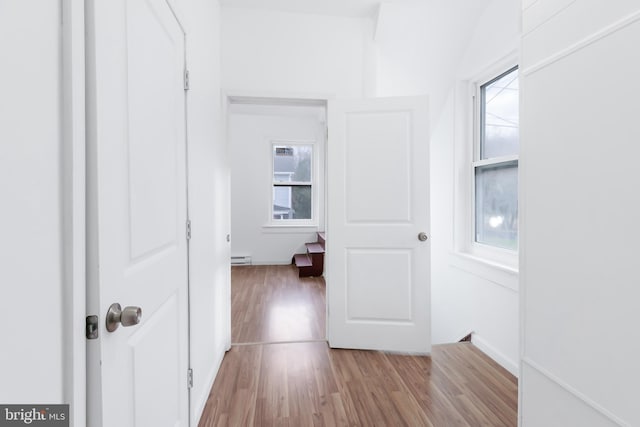 corridor with light hardwood / wood-style flooring and a baseboard radiator