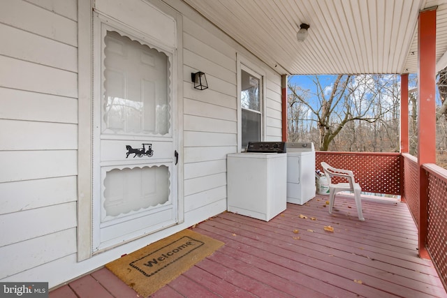 wooden terrace with covered porch and washer and clothes dryer