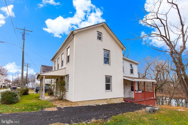 rear view of house featuring covered porch