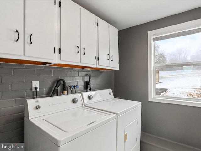 washroom with washer and dryer and cabinets